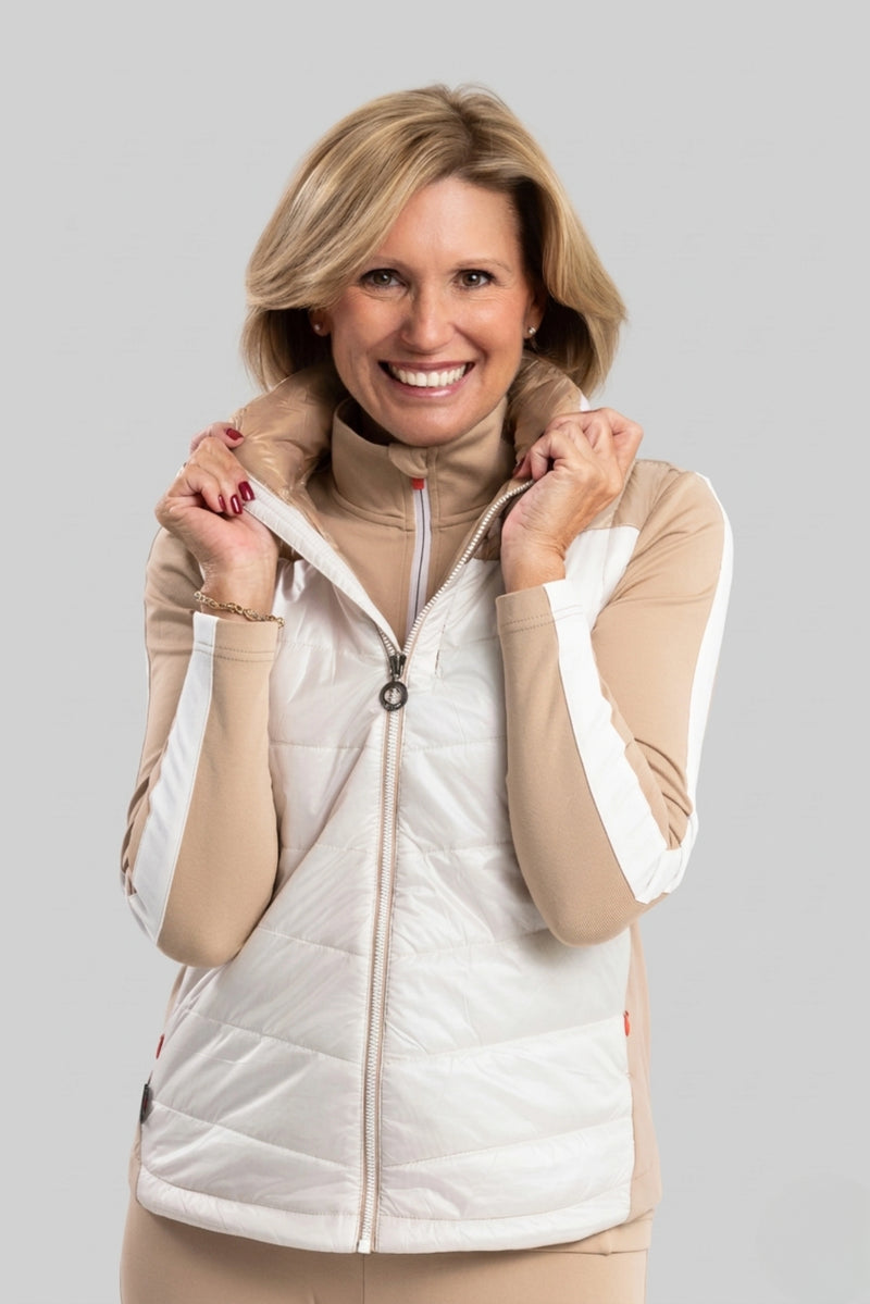 Woman wearing a beige and white quilted vest on a gray background